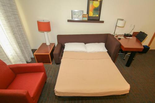 Habitación con sofá, mesa y cama en Residence Inn Newport News Airport en Newport News
