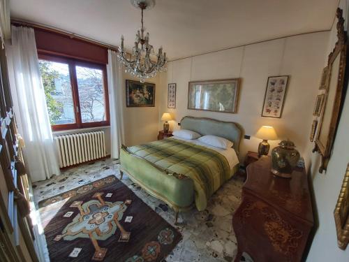 a bedroom with a bed and a chandelier at Villa Bice in Maresana in Ponteranica