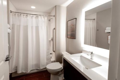 Baño blanco con lavabo y aseo en TownePlace Suites by Marriott Louisville Airport en Louisville