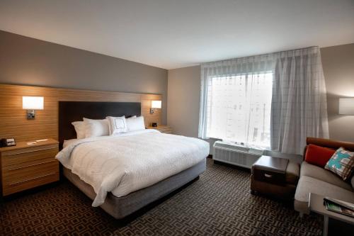 a hotel room with a large bed and a window at TownePlace Suites by Marriott Louisville Airport in Louisville