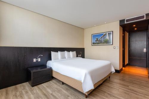 a large white bed in a hotel room at Tryp by Wyndham Belo Horizonte Savassi in Belo Horizonte