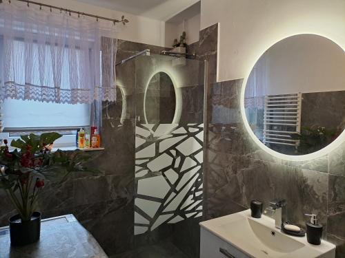 a bathroom with a sink and a mirror at Pokoje Gościnne u Grażynki in Nowy Sącz