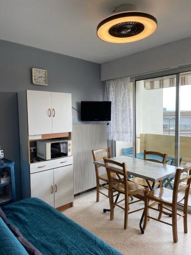 une cuisine et une salle à manger avec une table et des chaises dans l'établissement Appartement proche des Thermes, à Balaruc-les-Bains