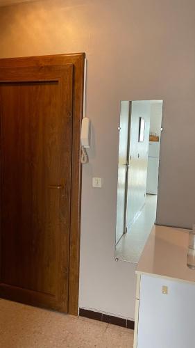 La salle de bains est pourvue d'une porte en bois et d'un miroir. dans l'établissement Appartement proche des Thermes, à Balaruc-les-Bains