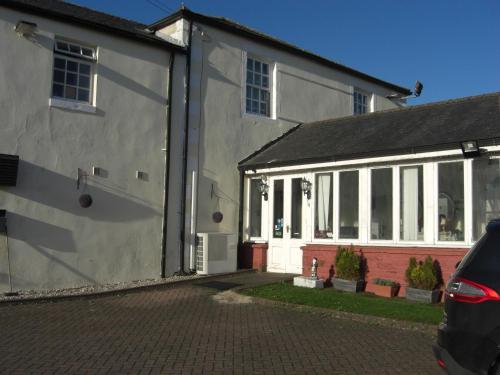 a white house with white windows and a driveway at Lynebank House Hotel, Bed & Breakfast in Carlisle