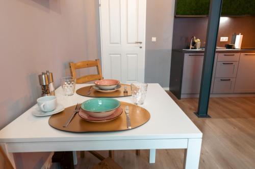 uma mesa branca com dois pratos e tigelas em MADU-Living Vienna - Egon em Viena