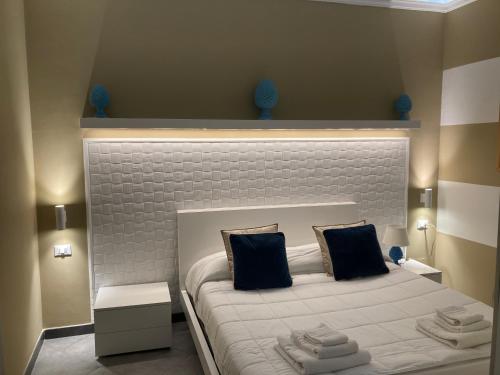 a bedroom with a large white bed with black pillows at B&B Palazzo Diaz in Marsala