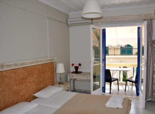 a bedroom with a bed and a view of a balcony at Borsalino Studios in Nydri