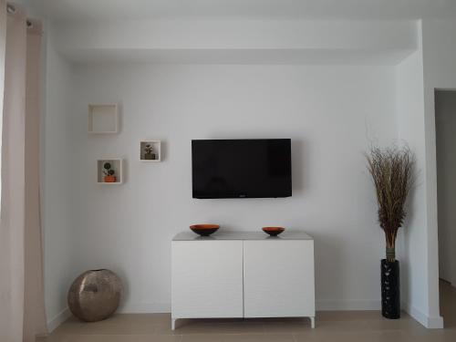 een woonkamer met een tv aan een witte muur bij NEW Palacio del Sol Torremolinos in Torremolinos