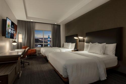 a hotel room with two beds and a desk at Courtyard by Marriott Houston Kemah in Kemah