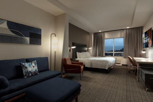 a hotel room with a bed and a living room at Courtyard by Marriott Houston Kemah in Kemah