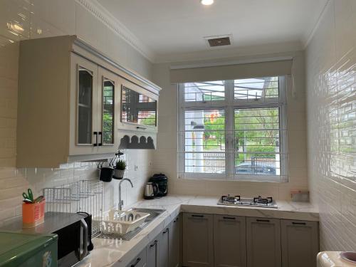 a kitchen with a sink and two windows at Eton Asia Kota Bunga Villas in Puncak