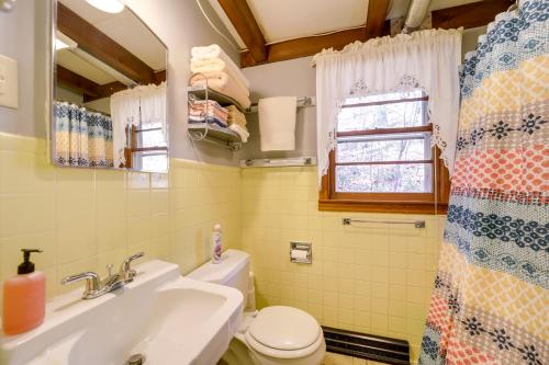 een badkamer met een wastafel, een toilet en een raam bij The Red Loft Candler Cottage 18 Mi to Asheville! in Candler