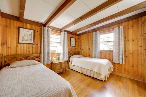 twee bedden in een kamer met houten wanden en houten vloeren bij The Red Loft Candler Cottage 18 Mi to Asheville! in Candler