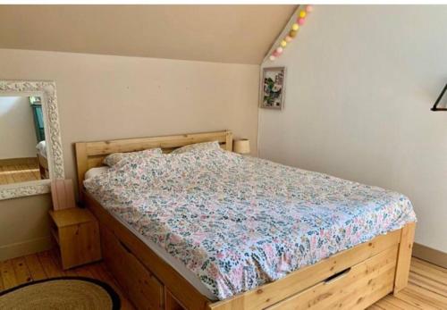 1 Schlafzimmer mit einem Holzbett mit einer Blumenbettdecke in der Unterkunft Maison bourgeoise in Fillé