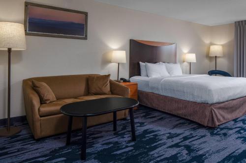 a hotel room with a bed and a couch at Fairfield Inn & Suites Jefferson City in Jefferson City