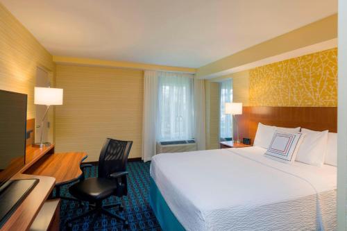 a hotel room with a large bed and a desk at Fairfield Inn & Suites by Marriott Paramus in Paramus