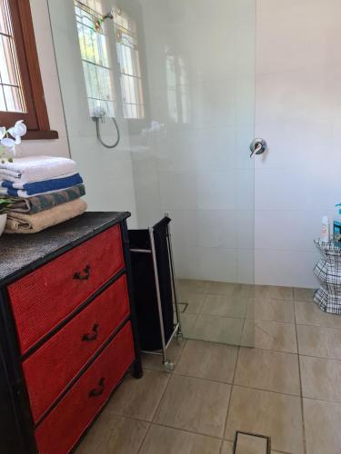 a bathroom with a red dresser and a shower at Vista unit Close to the City & Airport & Train station and Brighton Le Sands Beach in Sydney