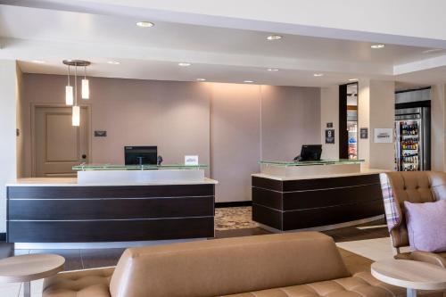a lobby with a waiting area with a couch and tables at Residence Inn by Marriott Bloomington in Bloomington