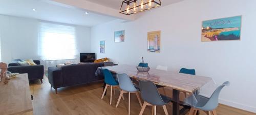 un salon avec une table et des chaises en bois dans l'établissement La Tribu -Maison Sablaise a 200m de la Grande Plage, à Les Sables-dʼOlonne