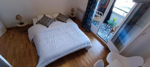 - une chambre avec un lit blanc et des oreillers dans l'établissement Marinas 2 - Agreable studio face au port Olona, à Les Sables-dʼOlonne