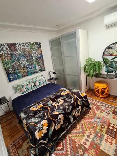 a bedroom with a bed with a comforter and a rug at Vista unit Close to the City & Airport & Train station and Brighton Le Sands Beach in Sydney