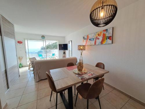 une salle à manger avec une table et des chaises et un salon dans l'établissement Ancora2- Appartement vue mer et place de parking, à Les Sables-dʼOlonne