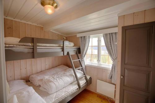 a room with two bunk beds and a window at Kvetos fjellgårdsutsikt in Beitostøl