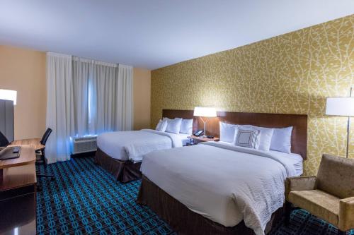 a hotel room with two beds and a chair at Fairfield Inn & Suites by Marriott Atlanta Acworth in Acworth