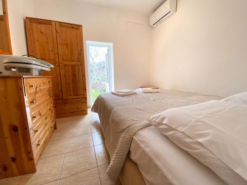 a bedroom with a bed and a dresser and a window at Pulchra Campis,Private Pool,Wifi,Parking in Nerokoúros