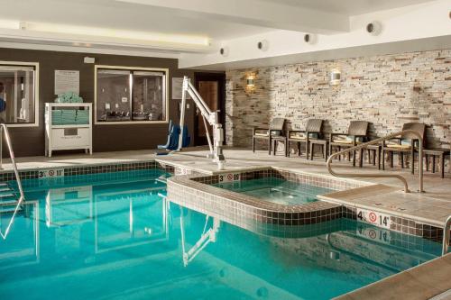 una piscina en una habitación de hotel con sillas alrededor en Fairfield by Marriott Waterbury Stowe en Waterbury
