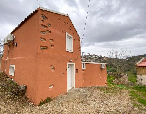 a red building with a white door on a hill at Pulchra Campis,Private Pool,Wifi,Parking in Nerokoúros