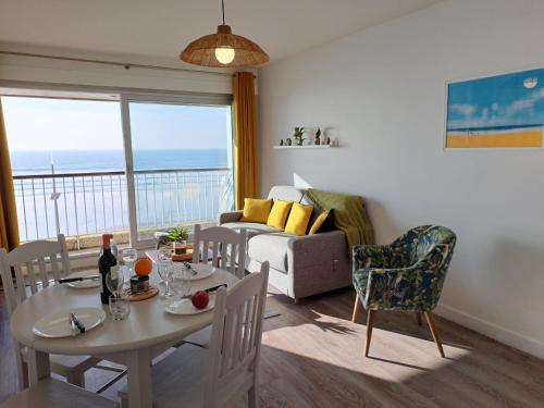 ein Wohnzimmer mit einem Tisch, Stühlen und einem Sofa in der Unterkunft MIREILLE - Appartement 4 etoiles vue mer - 2 a 4 pers in Les Sables-dʼOlonne