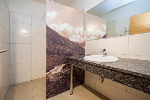 a bathroom with a sink and a mirror at Apparthotel Panorama in Flachau
