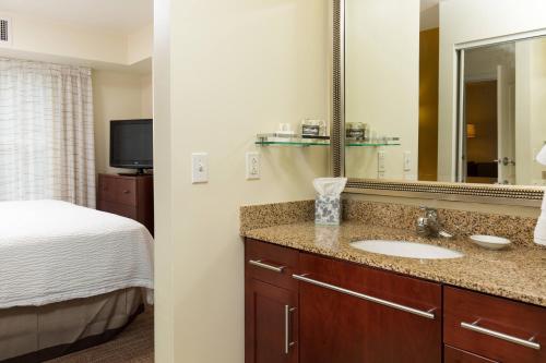 a bathroom with a sink and a bed and a mirror at Residence Inn Dayton North in Dayton