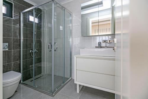 a bathroom with a shower and a sink and a toilet at Paradise Town Villa Belhamra in Belek