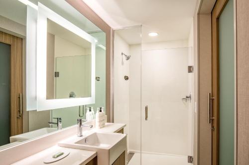 a bathroom with a sink and a shower at SpringHill Suites by Marriott Boston Logan Airport Revere Beach in Revere