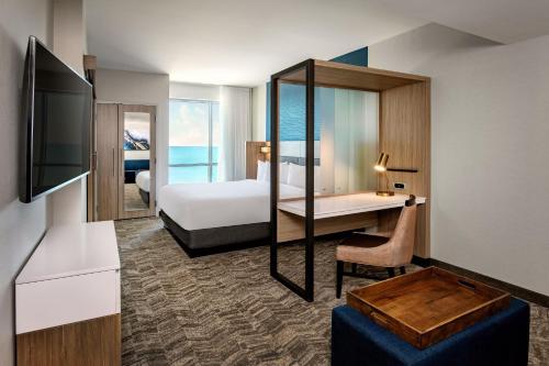 a hotel room with a bed and a desk at SpringHill Suites by Marriott Boston Logan Airport Revere Beach in Revere