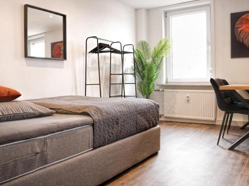 una camera da letto con un letto e uno specchio a parete di LIGHTPLACE • Größere Gruppen • 4 Einzelzimmer • Boxspring • Smart TV • Biergarten • Restaurant a Braunschweig