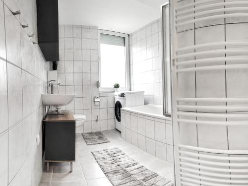 ein Badezimmer mit einem Waschbecken, einem WC und einer Badewanne in der Unterkunft LIGHTPLACE • Größere Gruppen • 4 Einzelzimmer • Boxspring • Smart TV • Biergarten • Restaurant in Braunschweig