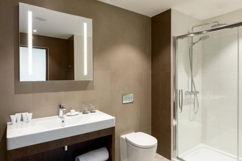 a bathroom with a sink and a shower and a toilet at AC Hotel by Marriott Belfast in Belfast