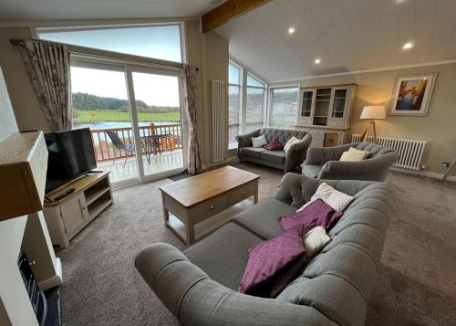 a living room with a couch and a television at Westlands Country Park in Annan