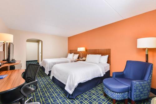 a hotel room with two beds and a blue chair at Fairfield Inn Corning Riverside in Corning
