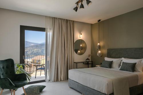 a bedroom with a bed and a chair and a balcony at Anthemis Living in Argostoli