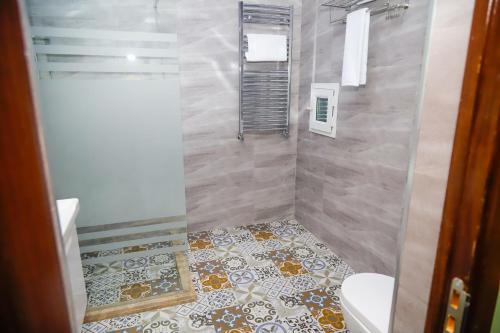 y baño con ducha, aseo y lavamanos. en Anatolia Hotel Baku, en Baku