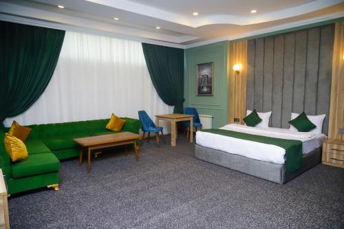 a hotel room with a bed and a couch at Anatolia Hotel Baku in Baku