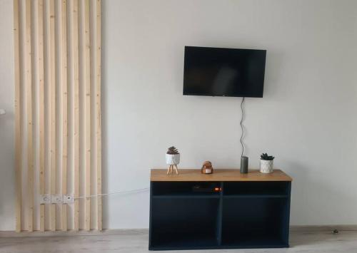 uma televisão em cima de um suporte com uma mesa em Superbe studio en résidence neuve em La Chapelle-Saint-Mesmin