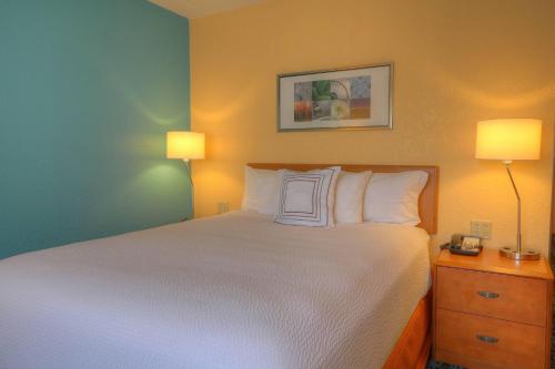 ein Bett in einem Hotelzimmer mit 2 Lampen und einem 6-dx-Bett in der Unterkunft Fairfield Inn & Suites Mt. Pleasant in Mount Pleasant