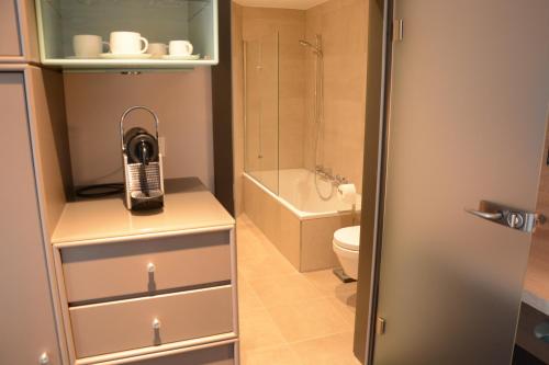 une petite salle de bains avec un téléphone sur une armoire dans l'établissement Bed&Bike Berliner Hof, à Saint-Vith