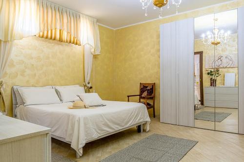 a bedroom with a large white bed and a mirror at Villa Etna Sea in Piedimonte Etneo